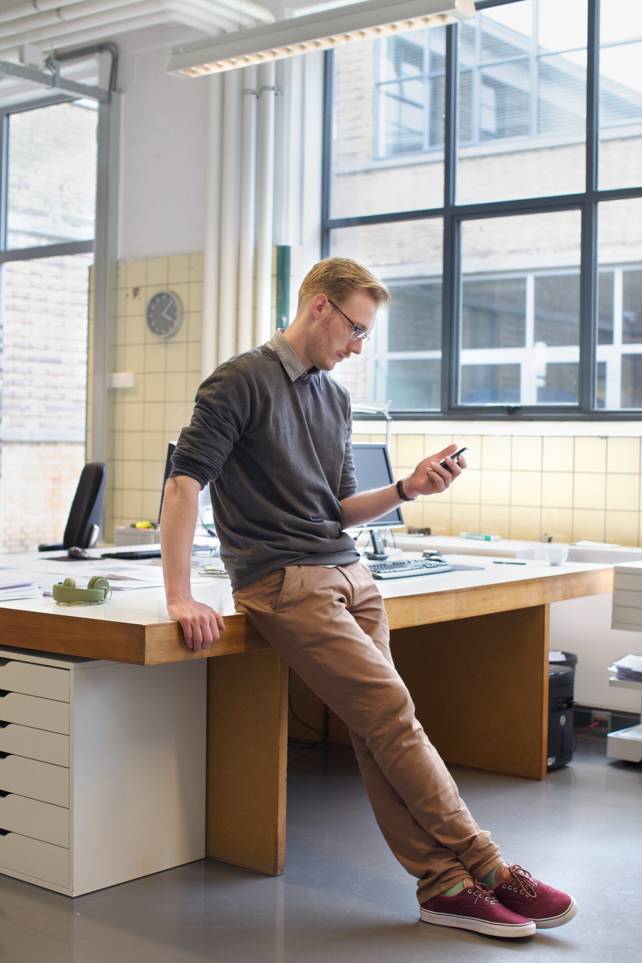 Male designers looking smartphone in creative office
